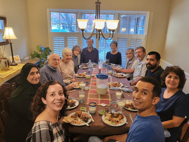 The Hashimi family enjoying a traditional Afghan meal they prepared for the C-U Welcome group to celebrate the close of their sponsorship